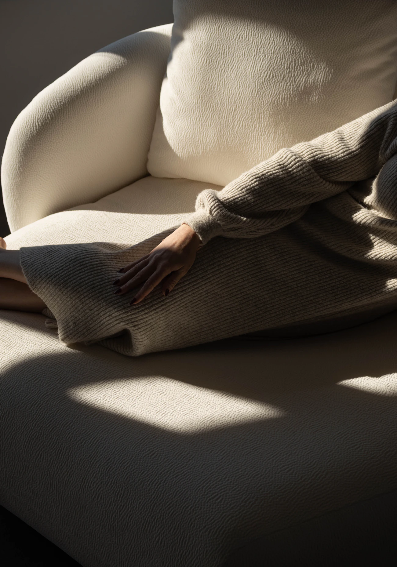 Iemand die ontspant in een crèmekleurige fauteuil in zacht licht